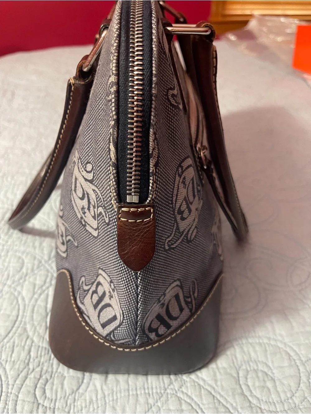 Dooney and Bourke Monogram Denim Donegal Dome Satchel with brown leather trim.